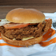 Burger King's hand-breaded Ch'King sandwich with lettuce and tomato sitting atop serving pouch